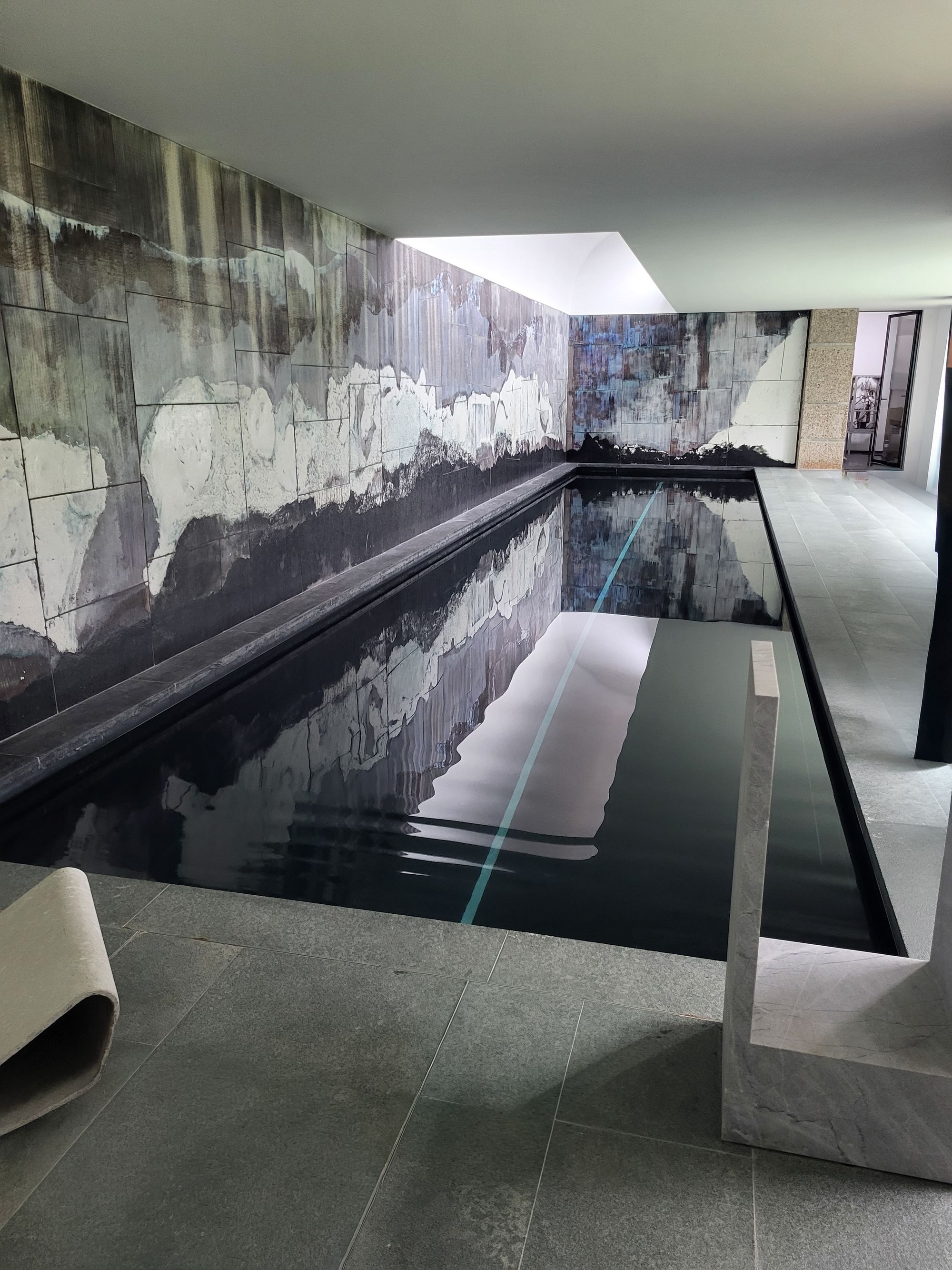 Piscine intérieure à Uccle, bassin sombre et grande verrière